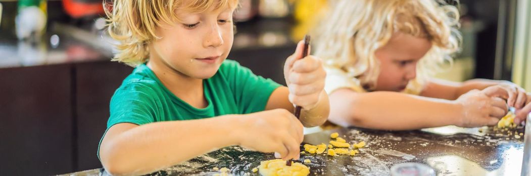 Two children a boy and a girl make cookies from dough. BANNER, LONG FORMAT