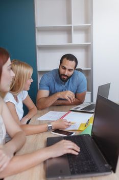 Vertical shot of three colleagues chatting, discussing business strategy