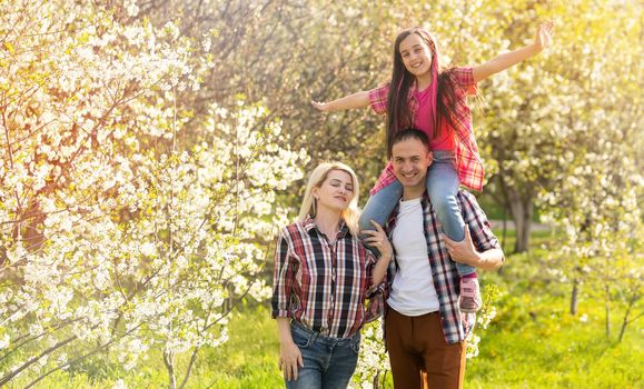 Happy young family spending time together outside in green nature.