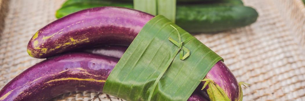 BANNER, LONG FORMAT Eco-friendly product packaging concept. Vegetables wrapped in a banana leaf, as an alternative to a plastic bag. Zero waste concept. Alternative packaging.