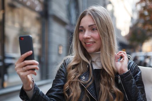 Close up of a woman taking a selfie with her smart phone outdoors