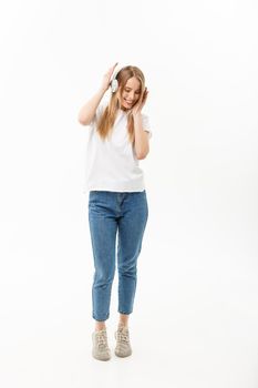 Lifestyle Concept: Portrait of a cheerful happy girl student listening to music with headphones while dancing isolated over white background.