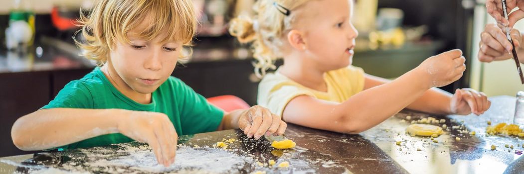 Two children a boy and a girl make cookies from dough. BANNER, LONG FORMAT