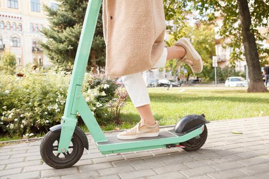 Unrecognizable woman riding electric scooter in the park