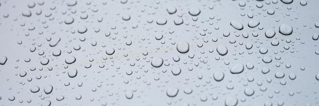 Water drops on glass, gray rainy background, close-up. Sadness and loneliness. Cleanliness and freshness. Design element