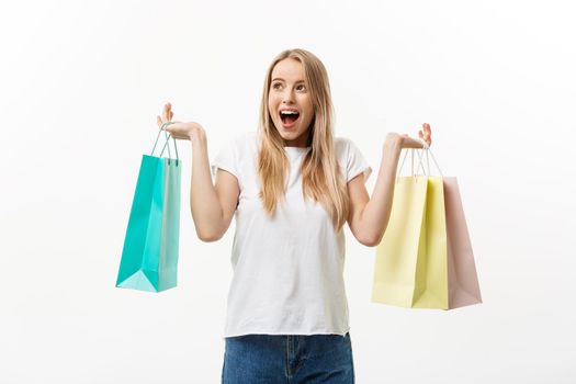Lifestyle Concept: Portrait shocked young brunette woman in white summer shirt posing with shopping bags isolated over white background