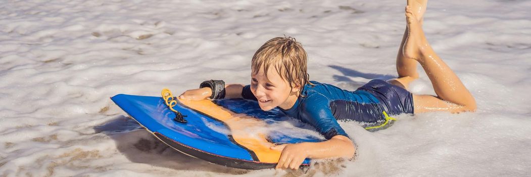 Happy Young boy having fun at the beach on vacation, with Boogie board. BANNER, LONG FORMAT