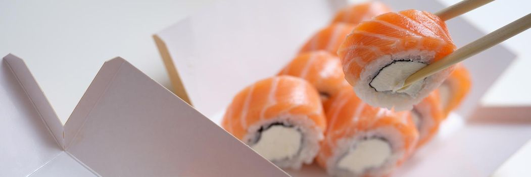 Beautiful set of fresh sushi with caviar and salmon in a box, close-up. Cooking traditional Japanese food, fish rolls, appetizer