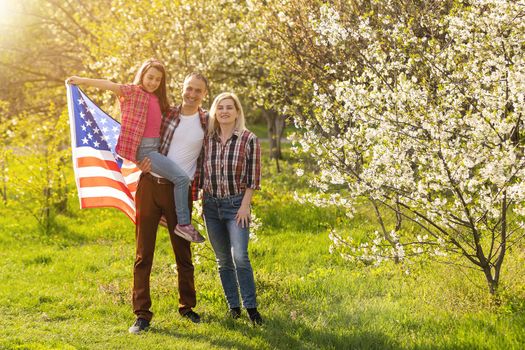 July 4th: American Family Behind US Flag.