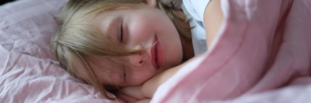 Little cute girl sleeping peacefully on the bed, close-up. Calm atmosphere for a child, carefree childhood, tranquility
