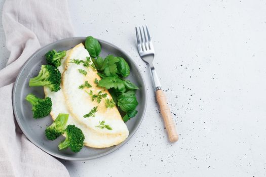 Protein omelet with broccoli and greens on a gray plate on a gray background.Healthy food concept. Super food for weight loss