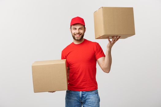 Portrait delivery man in cap with red t-shirt working as courier or dealer holding two empty cardboard boxes. Receiving package. Copy space for advertisement.