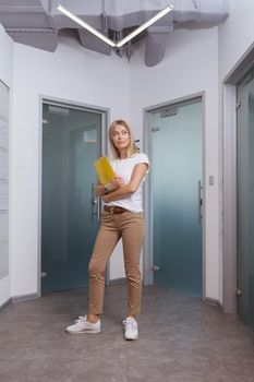 Vertical full length shot of a beautiful young female entrepreneur in a modern workplace