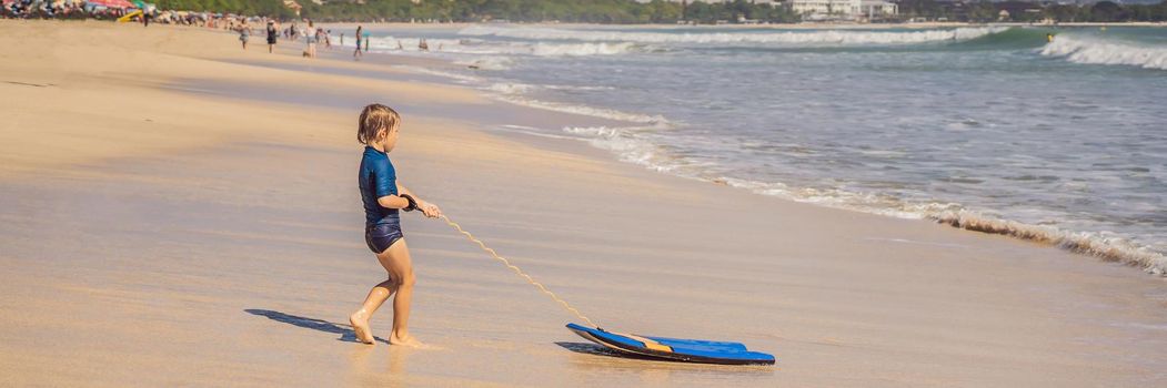 Happy Young boy having fun at the beach on vacation, with Boogie board. BANNER, LONG FORMAT