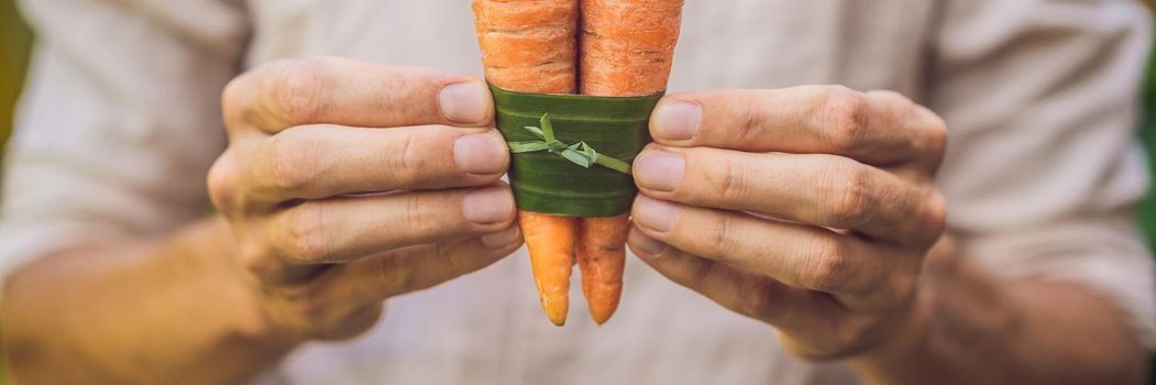 BANNER, LONG FORMAT Eco-friendly product packaging concept. Carrot wrapped in a banana leaf, as an alternative to a plastic bag. Zero waste concept. Alternative packaging.