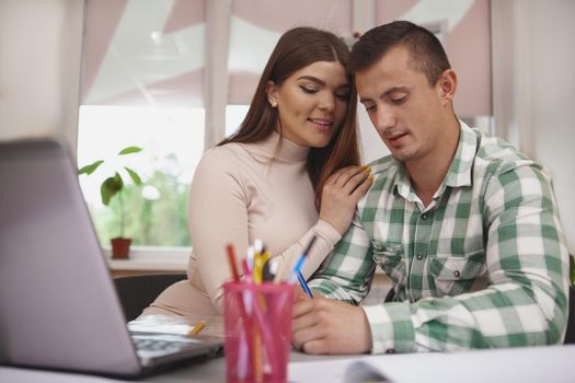 Intelligence, couples, youth concept. Beautiful college couple preparing for exams together, working on a project on their computer