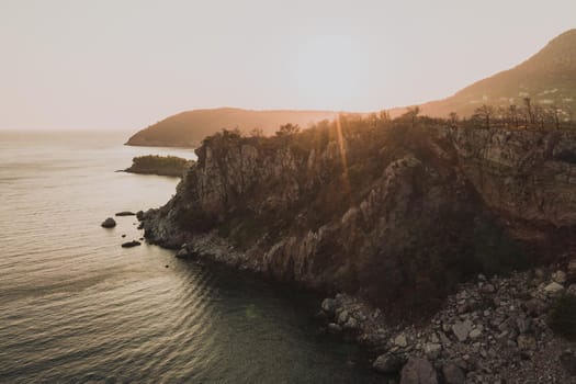 Aerial top evening view drone above Adriatic sea in Montenegro. panoramic sunny marine mountain sunset. summer nature wallpaper. dark calm water rock. mountains coast seaside. Amazing outdoors view