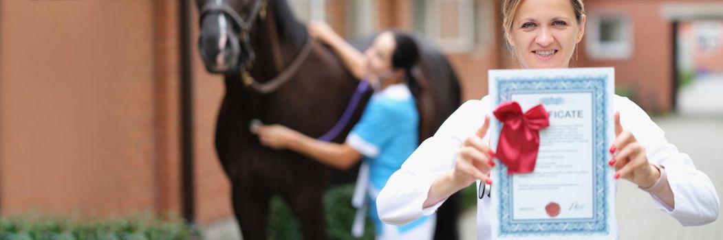 Woman veterinarian shows the horse health certificate, close-up. Inspection of the animal before the competition and exhibition