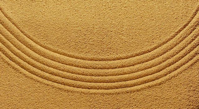 Background of yellow warm sand in summer with an abstract pattern of a smooth line of the arc for the harmony of the spirit.