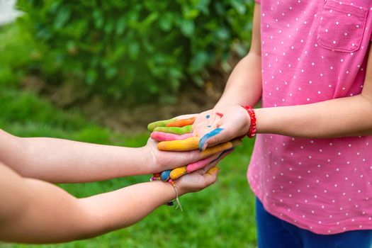 Hands of a child with a drawn emoticon. Selective focus.