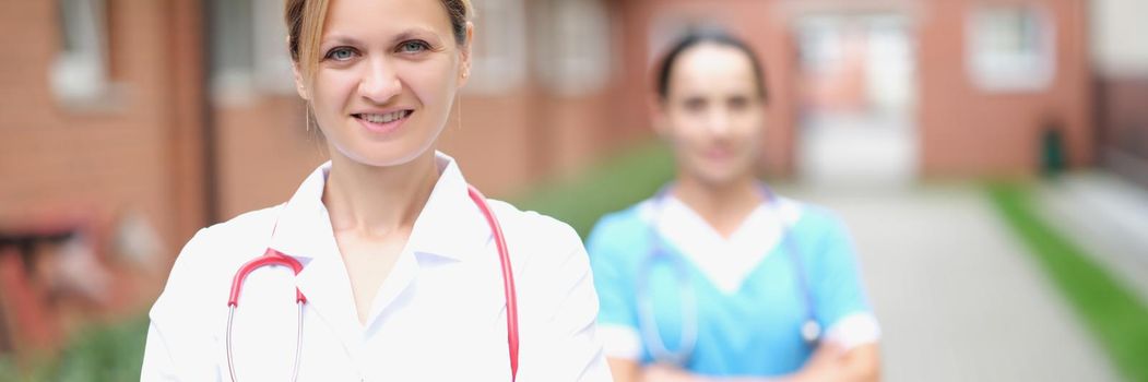 A woman doctor and a nurse are standing on the street near the clinic, close-up. Professional staff of the vetirina clinic