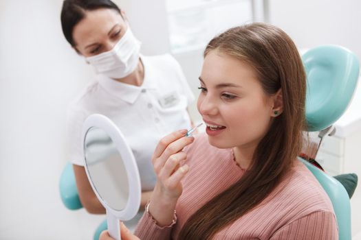 Young woman learning using interdental toothbrush at dentists office