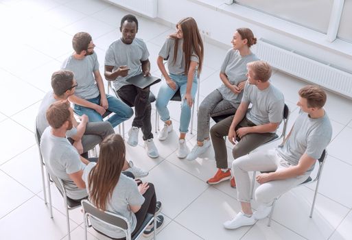 top view. discussion group of young people sitting in a circle . the concept of unity