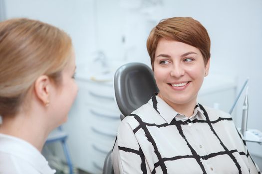 Young woman smiling at her dentist after dental treatment