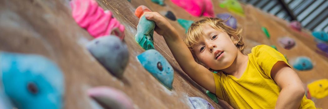 little boy climbing a rock wall in special boots. indoor. BANNER, LONG FORMAT