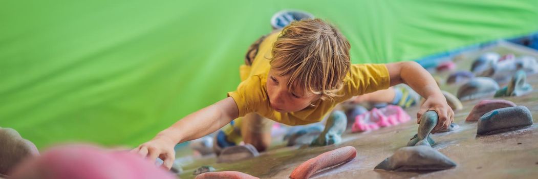 little boy climbing a rock wall in special boots. indoor. BANNER, LONG FORMAT