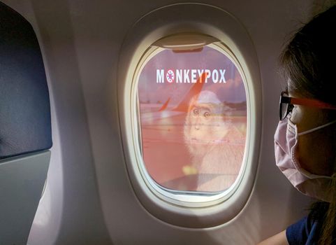 Woman wear surgical mask sit on passenger seat near cabin window of the airplane with monkeypox outbreak concept. Monkeypox is caused by monkeypox virus. Traveling by plane during monkeypox outbreak.