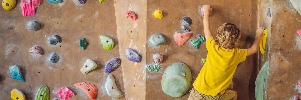 little boy climbing a rock wall in special boots. indoor. BANNER, LONG FORMAT