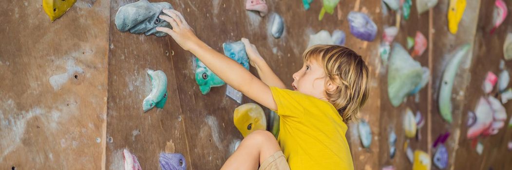 little boy climbing a rock wall in special boots. indoor. BANNER, LONG FORMAT