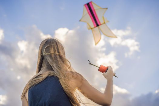 A young woman launches a kite on the beach. Dream, aspirations, future plans.