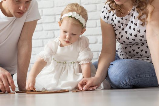 Child girl with cochlear implant plays at home. Hear impairment and diversity and hearing aid