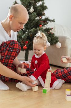 Toddler child with cochlear implant decorating christmas tree deafness and innovating medical technologies for hearing aid