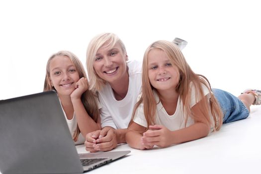 close up. mom and daughters lying in front of an open laptop. people and technology