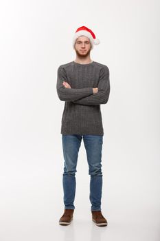 Holiday Concept - Young beard man in sweater crossed arms posing on white background.