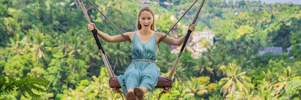 Young woman swinging in the jungle rainforest of Bali island, Indonesia. Swing in the tropics. Swings - trend of Bali. BANNER, LONG FORMAT