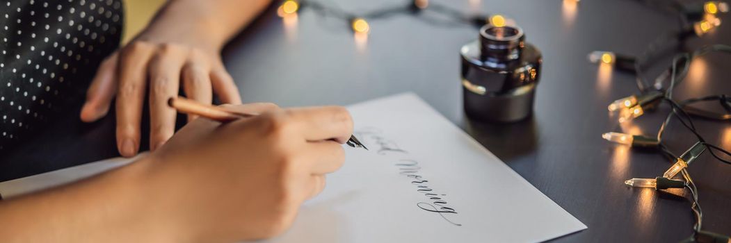 BANNER, LONG FORMAT Good morning. Calligrapher Young Woman writes phrase on white paper. Inscribing ornamental decorated letters. Calligraphy, graphic design, lettering, handwriting, creation concept.