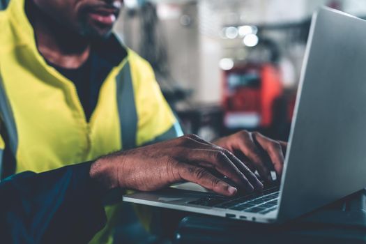 Factory worker working with laptop computer to do adept procedure checklist . Factory production line operator occupation quality control concept .