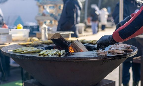 Smelt fish is fried on a large grill during the fish festival in Svetlogorsk Raushen, Kalinigrad region, Russia, near the Baltic sea. High quality photo.
