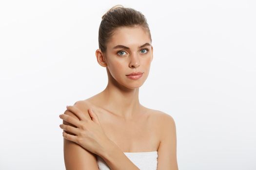 Beautiful Caucasian woman with towel against a white background