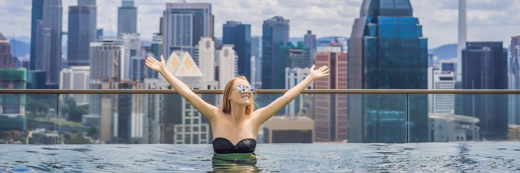 Young woman in outdoor swimming pool with city view in blue sky. Rich people. BANNER, LONG FORMAT BANNER, LONG FORMAT