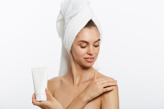 Woman applying cream on shoulder on a white background