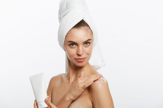 Woman applying cream on shoulder on a white background