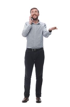 in full growth. young businessman talking on his smartphone. isolated on white background