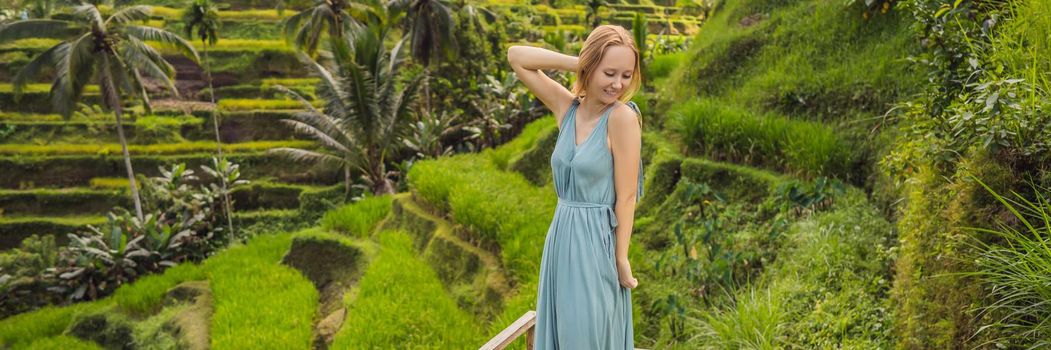 BANNER, LONG FORMAT Beautiful young woman walk at typical Asian hillside with rice farming, mountain shape green cascade rice field terraces paddies. Ubud, Bali, Indonesia. Bali travel concept.