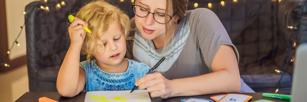 A teacher, a tutor for home schooling and a teacher at the table. Or mom and daughter. Homeschooling. BANNER, LONG FORMAT