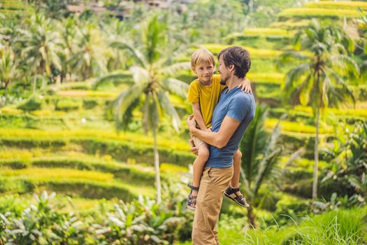 Dad and son travelers on Beautiful Rice Terraces against the background of famous volcanoes in Bali, Indonesia Traveling with children concept.